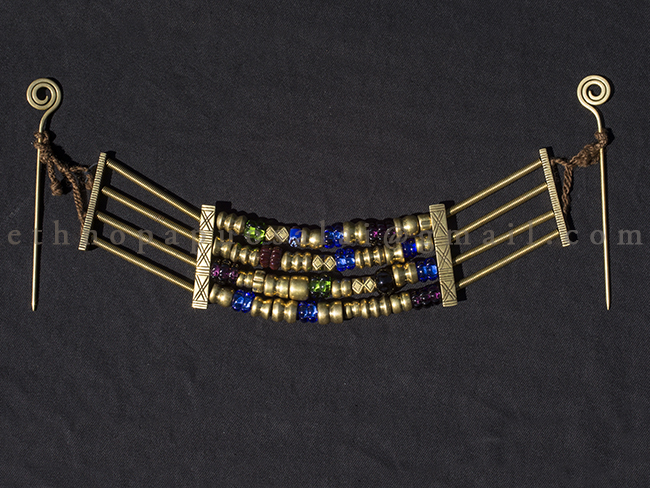 Krūtinės papuošalas iš žalvario ir stiklo karolių bei skirstiklių. Pagal radinį iš Palangos, X –XIa. Kuršiai.